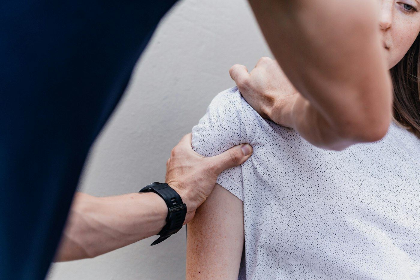 Physiotherapeut behandelt die Schulter einer Patientin
